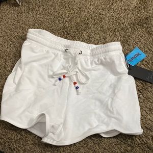 A white pair of shorts with strings with white blue and red beads size small